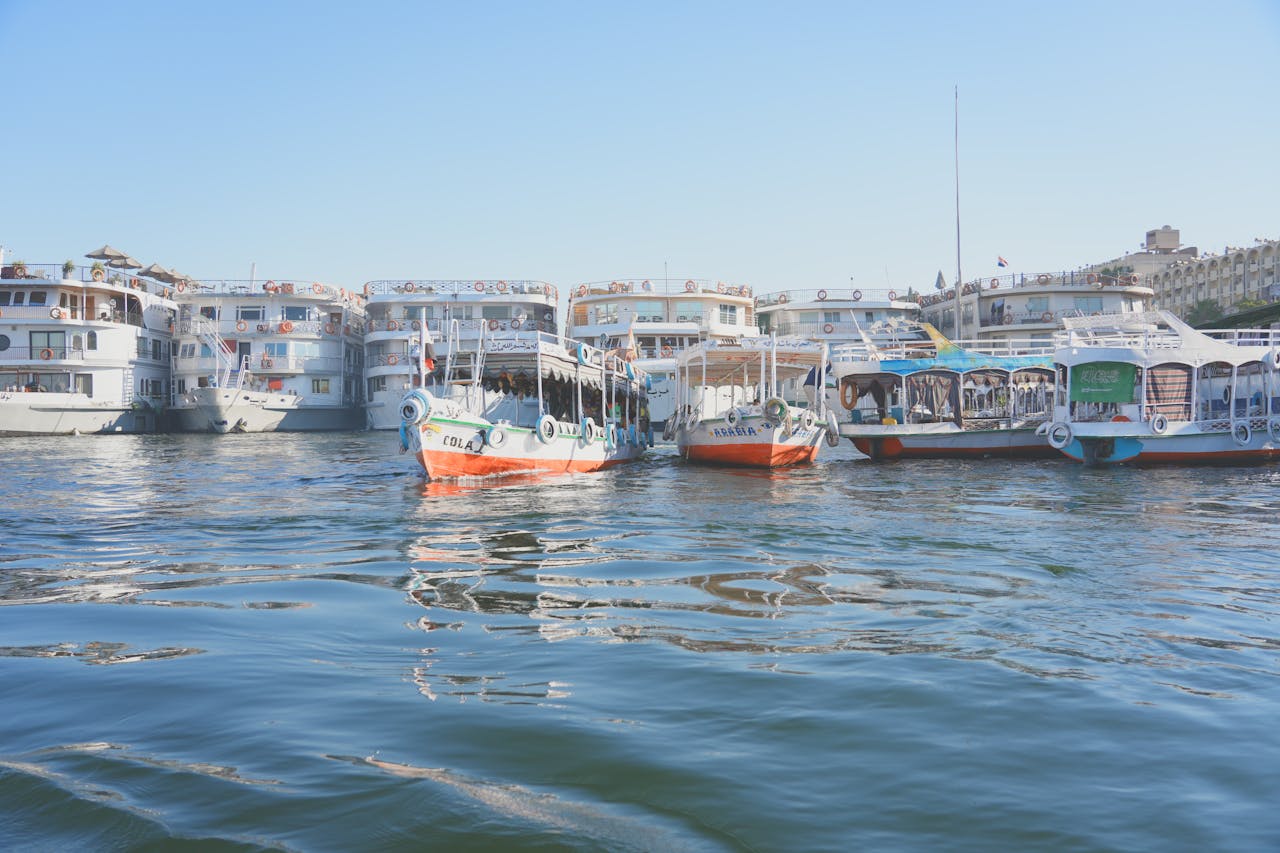 A bustling harbor scene with various ferries and boats moored under a clear blue sky.