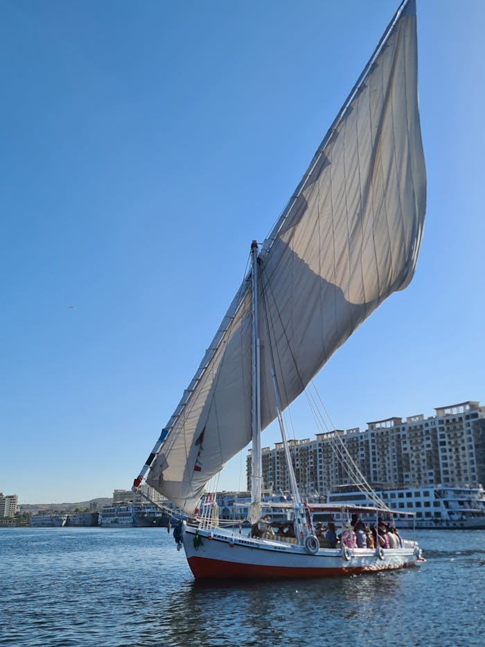 Traditional Egyptian boat sailing on the Nile River with a clear sky backdrop.